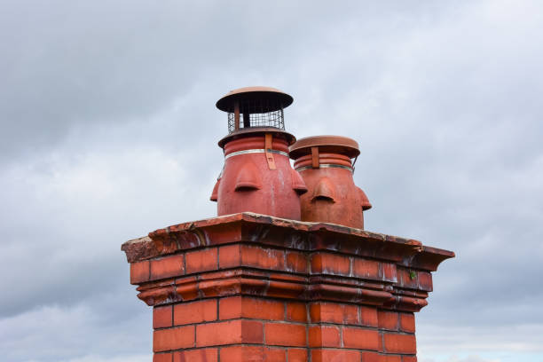 Clay chimney pots on the top of red brick chimney stack of a residential house